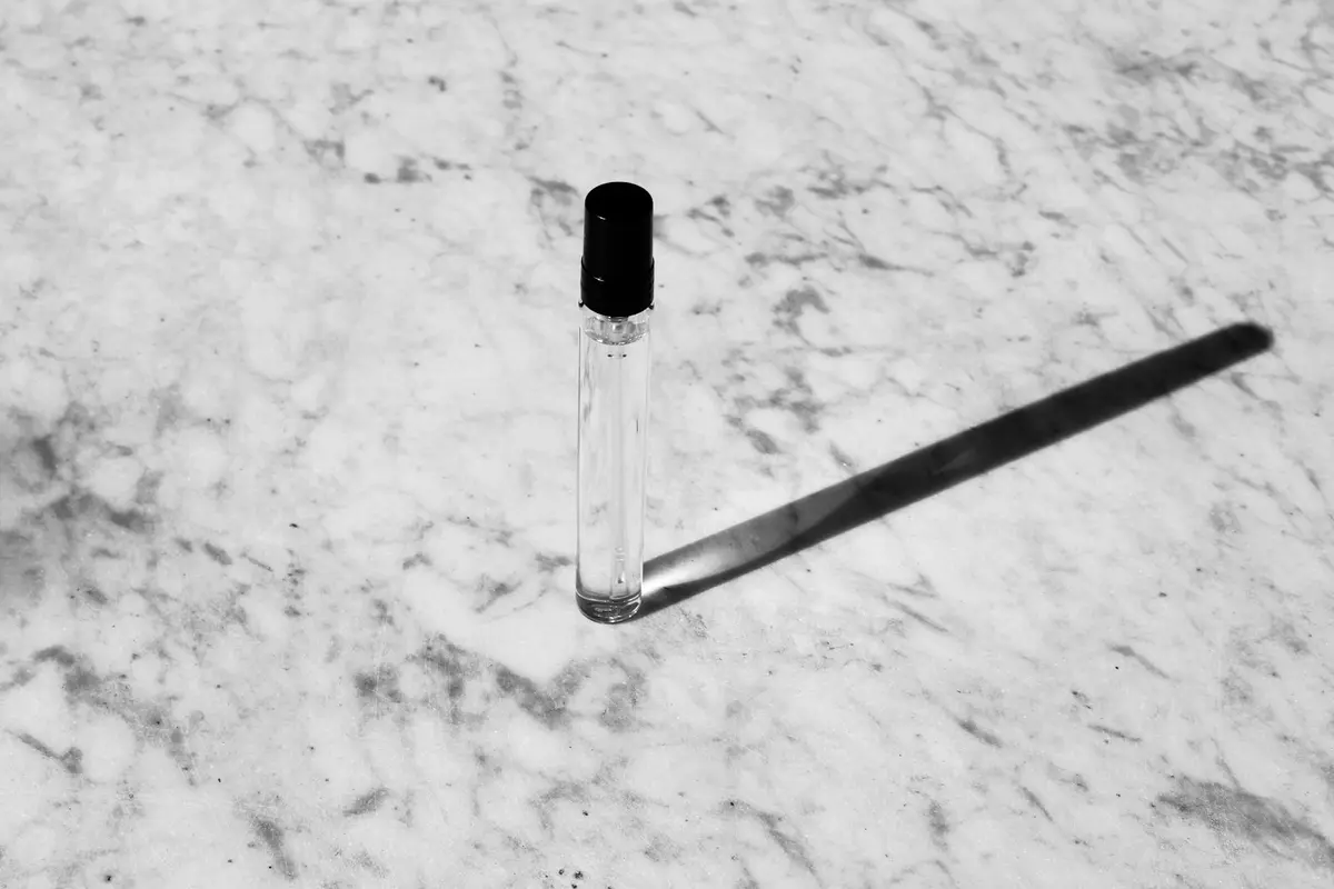 A glass perfume decant atomiser on marble